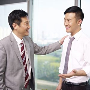 asian business people standing and talking in office