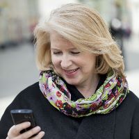 Mature blonde woman reads the message on the phone